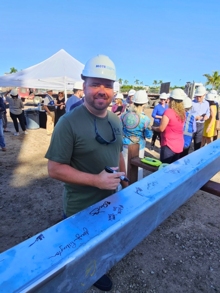 Benderson Development team signing steel bar